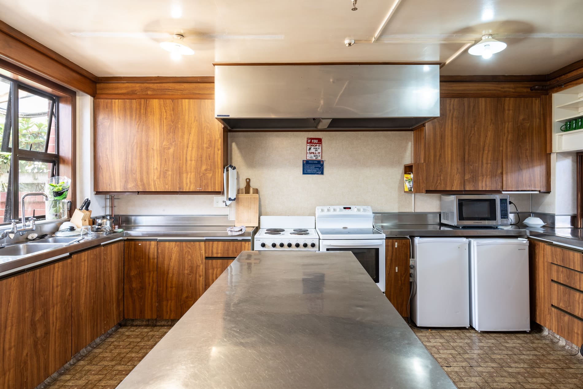 Commercial shared kitchen with stovetops, microwave and storage